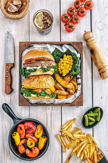 A mouth-watering gourmet burger meal with fries, peppers, and corn, perfect for a delicious dining experience. HD phone wallpaper