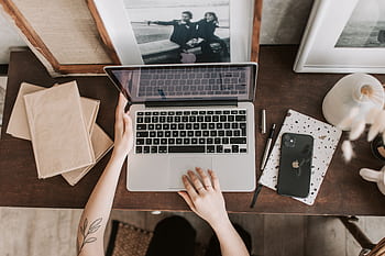 An aesthetic workspace featuring a laptop, smart, and stationery items from a top-down view. HD wallpaper