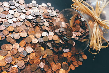 Spilled jar of pennies creating a pattern of coins representing savings and finance. HD wallpaper