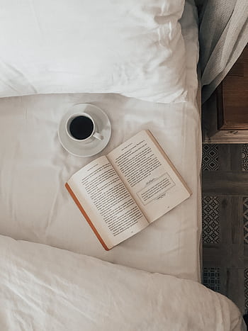 A calming indoor scene with a book and coffee on the bed, perfect for relaxation and leisure moments. HD phone wallpaper