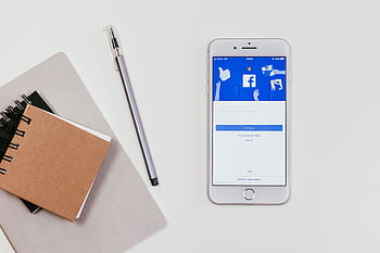 Minimalist workspace featuring a smart with social media login and notepad. HD wallpaper