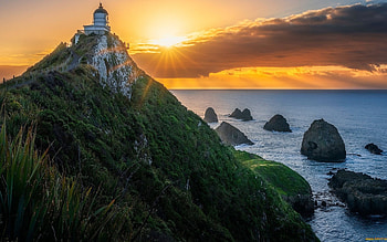 Lighthouse in New Zealand, sea, New Zealand, lighthouse, sunbeams, rocks, cloud HD wallpaper
