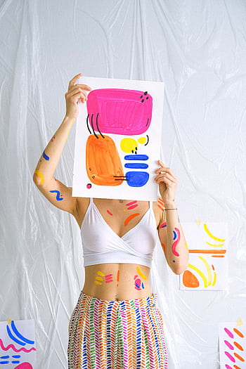 Bright abstract art piece held by decorated woman, embracing creativity. HD phone wallpaper