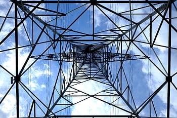 Looking up at a steel power pylon against a bright blue sky. HD wallpaper
