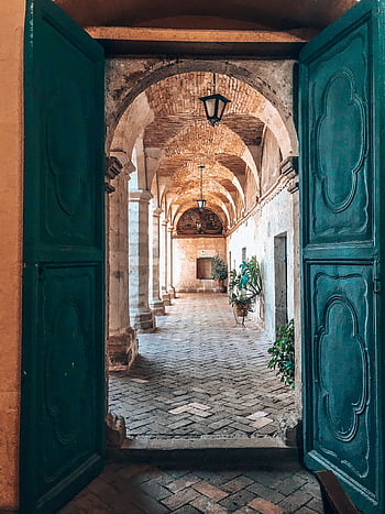 Rustic architectural corridor view through green doors in Arequipa, Peru. HD phone wallpaper