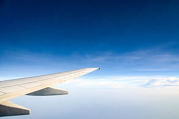 Airplane wing during flight offers a serene view of the sky and clouds. HD wallpaper