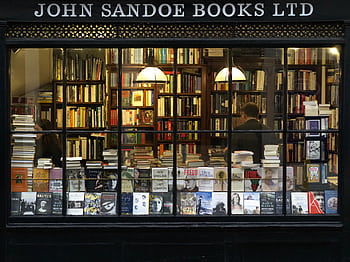 A cozy London bookstore showcasing various books through a classic window display. HD wallpaper