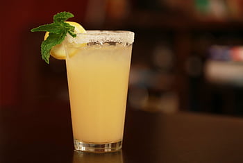 Chilled lemon-mint cocktail with a sugared rim, perfect for summer refreshment. HD wallpaper