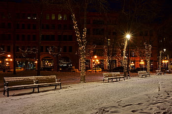 Snowy urban park in Saint Paul, MN, illuminated by festive lights at night. HD wallpaper