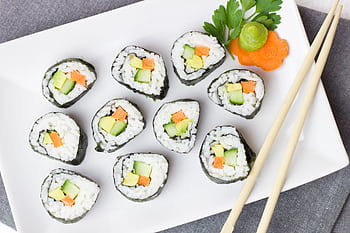 Top view of vegetable sushi rolls with chopsticks and wasabi on a white plate. HD wallpaper