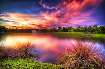Sunset at Vero beach, colorful, glow, colors, haze, beach, fountain, , amazing, water, sunset, beautiful, grass, lake, purple, mirrored, clouds, nature, sky, lovely HD wallpaper