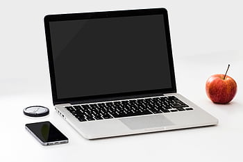 A minimalist workspace featuring a laptop, smart, and an apple on a clean white desk. HD wallpaper