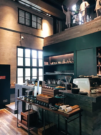 Trendy café interior featuring a modern barista counter with pastries and coffee essentials. HD phone wallpaper