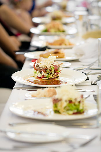 Long dining table set with gourmet salads, perfect for a fine dining experience. HD phone wallpaper