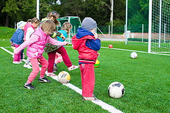 Kids having fun playing soccer outdoors on a sunny day in a park. HD wallpaper