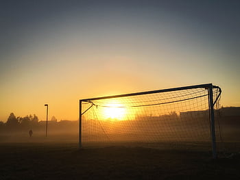 Soccer goal silhouetted against a misty sunrise in a tranquil Mississauga field. HD wallpaper