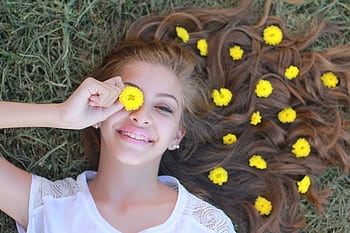Smiling girl with flowers in hair, embracing summer vibes. HD wallpaper