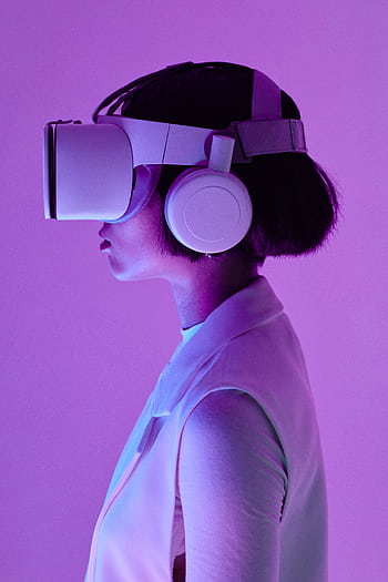 Side profile of a woman wearing VR goggles in a studio with purple lighting, embodying future tech. HD phone wallpaper