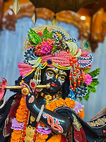 Intricate sculpture of a Hindu deity adorned with vivid colors and elaborate decorations. HD phone wallpaper