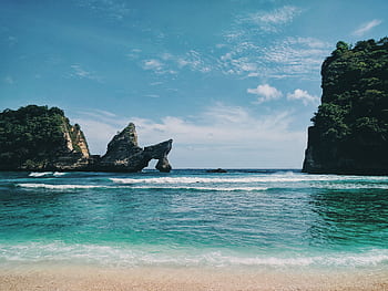 Scenic view of Bali's coastline with unique rock formations, clear turquoise waters, and a serene sky. HD wallpaper