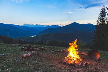 Cozy campfire against a mountain backdrop at twilight in Valea Drăganului, Romania. HD wallpaper