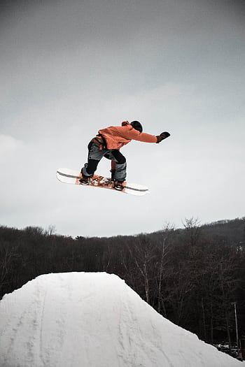 Capture the excitement of snowboarding with this action-packed leap from a snowy ramp. HD phone wallpaper
