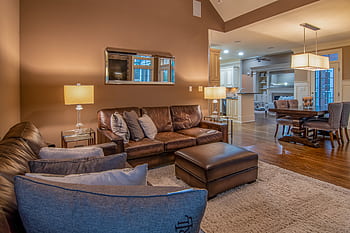Spacious living room with modern furniture and warm lighting for a cozy atmosphere. HD wallpaper