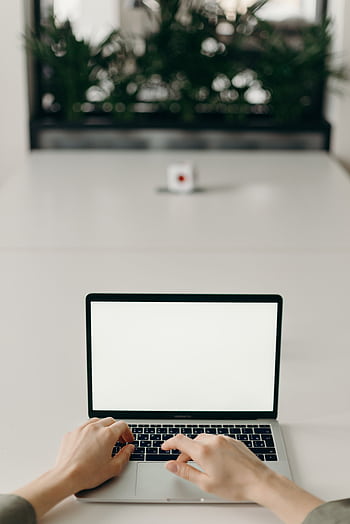 Hands typing on a laptop with a blank screen in a minimalist workspace. HD phone wallpaper