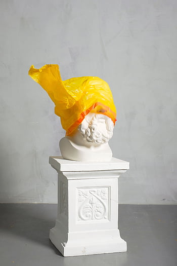 A classic sculpture covered with a yellow plastic bag symbolizing modern environmental challenges. HD phone wallpaper