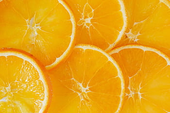 Close-up of vibrant and fresh orange slices showcasing juicy texture and color. HD wallpaper