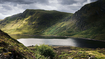 Lake Between Mountain Hills Stones Bushes Grass Reflection On Water White Black Clouds Sky Nature HD wallpaper