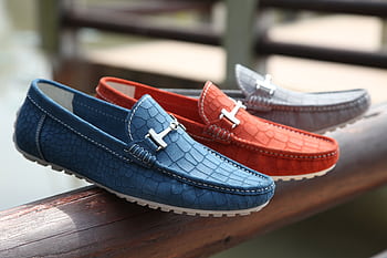 Fashionable leather loafers in various colors displayed on a wooden railing outdoors. HD wallpaper