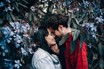 Happy couple sharing a romantic moment surrounded by beautiful blue flowers. HD wallpaper