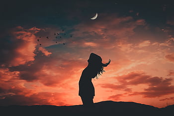 A silhouetted person under a crescent moon at twilight, evoking tranquil and peaceful vibes. HD wallpaper