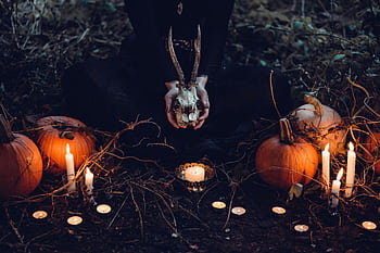 Eerie Halloween scene with pumpkins, candles, and a skull. Perfect for creating a spooky atmosphere. HD wallpaper