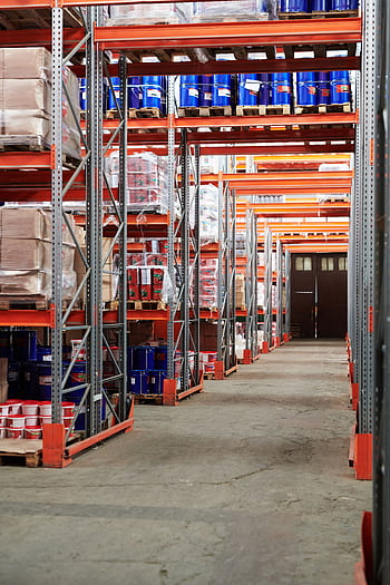 Industrial warehouse interior with organized shelves stacked with packages and goods. HD phone wallpaper