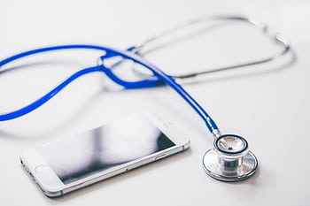 A smart and blue stethoscope on a clean white surface, emphasizing modern healthcare. HD wallpaper