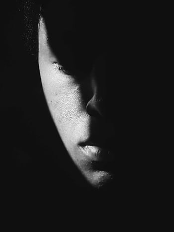 Moody black and white portrait of a man with dramatic shadows highlighting his face. HD phone wallpaper
