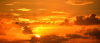 Captivating and vivid orange sunset with dramatic clouds enhancing the sky's beauty. HD wallpaper