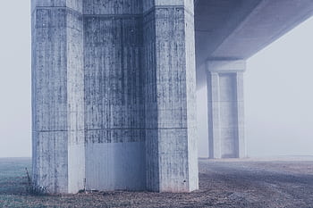 Misty view of concrete bridge columns in a foggy urban environment. HD wallpaper