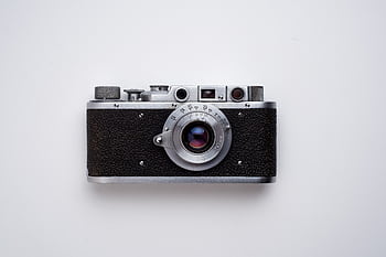 Classic vintage film camera captured in a minimalist flat lay style on a white background. HD wallpaper