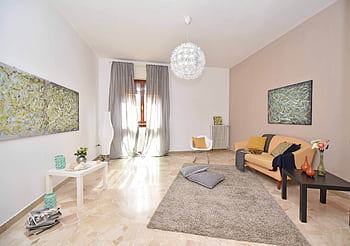 A spacious, modern living room with stylish decor and abundant natural light from large windows. HD wallpaper