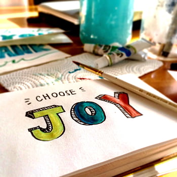 Colorful painting setup with 'Choose Joy' text, evoking a positive and creative vibe. HD phone wallpaper