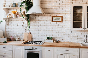 Stylish kitchen interior with modern appliances, wooden counters, and greenery accents. HD wallpaper
