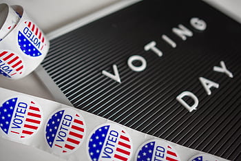 I Voted stickers with an American flag design and Voting Day sign symbolize U.S. electoral participation. HD wallpaper
