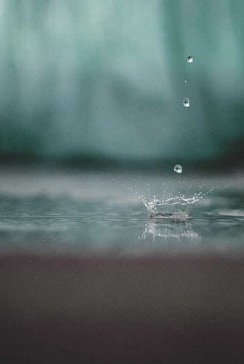Close-up of a raindrop splash, capturing pure water droplets in motion outdoors. HD phone wallpaper