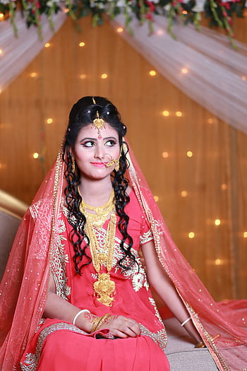 Elegant Indian bride wearing traditional attire with gold jewelry and intricate details. HD phone wallpaper