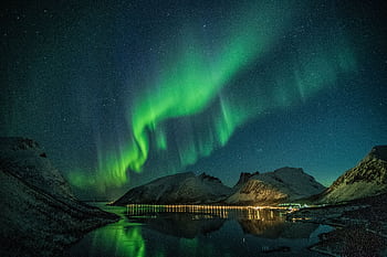 Mesmerizing northern lights illuminating snowy mountains and reflecting on a tranquil lake under a starry night sky. HD wallpaper