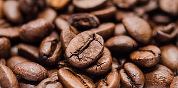 Rich and textured close-up of roasted coffee beans, ideal for coffee lovers. HD wallpaper