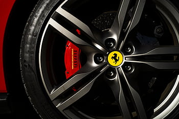 Detailed view of a Ferrari wheel and brake showcasing luxury automotive design. HD wallpaper